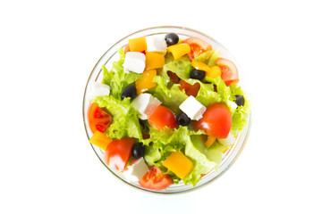 Greek salad in a glass bowl Isolated on white background