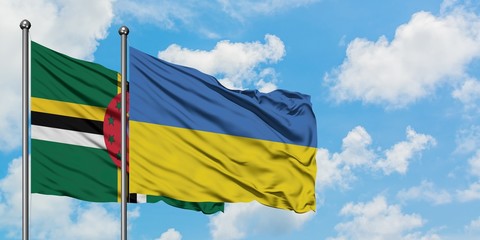Dominica and Ukraine flag waving in the wind against white cloudy blue sky together. Diplomacy concept, international relations.