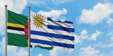 Dominica and Uruguay flag waving in the wind against white cloudy blue sky together. Diplomacy concept, international relations.