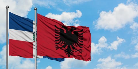 Dominican Republic and Albania flag waving in the wind against white cloudy blue sky together. Diplomacy concept, international relations.