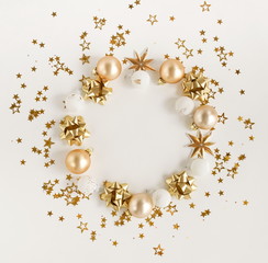 Fototapeta premium Christmas background . circle wreath of christmas tree decorations balls white and gold color and sparkle stars on white background with empty copy space for text. holiday concept for invitation.