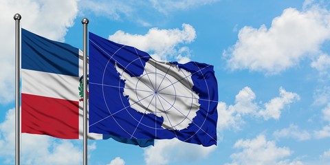 Dominican Republic and Antarctica flag waving in the wind against white cloudy blue sky together. Diplomacy concept, international relations.