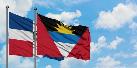 Dominican Republic and Antigua and Barbuda flag waving in the wind against white cloudy blue sky together. Diplomacy concept, international relations.