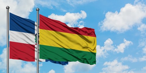 Dominican Republic and Bolivia flag waving in the wind against white cloudy blue sky together. Diplomacy concept, international relations.