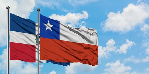 Dominican Republic and Chile flag waving in the wind against white cloudy blue sky together. Diplomacy concept, international relations.