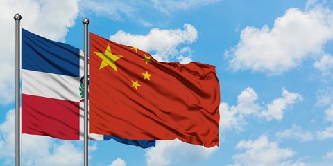 Dominican Republic and China flag waving in the wind against white cloudy blue sky together. Diplomacy concept, international relations.