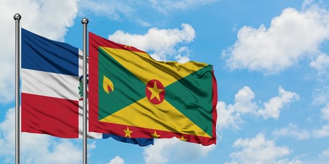 Dominican Republic and Grenada flag waving in the wind against white cloudy blue sky together. Diplomacy concept, international relations.