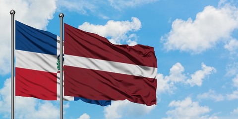 Dominican Republic and Latvia flag waving in the wind against white cloudy blue sky together. Diplomacy concept, international relations.