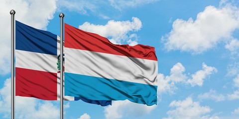 Dominican Republic and Luxembourg flag waving in the wind against white cloudy blue sky together. Diplomacy concept, international relations.