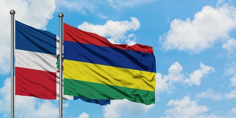 Dominican Republic and Mauritius flag waving in the wind against white cloudy blue sky together. Diplomacy concept, international relations.