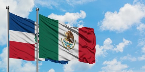 Dominican Republic and Mexico flag waving in the wind against white cloudy blue sky together. Diplomacy concept, international relations.