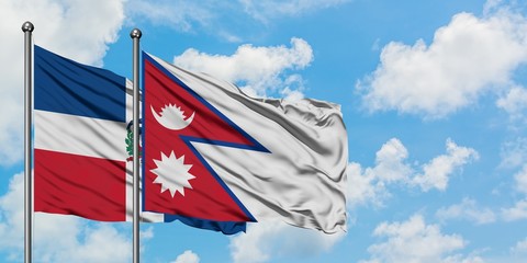 Dominican Republic and Nepal flag waving in the wind against white cloudy blue sky together. Diplomacy concept, international relations.
