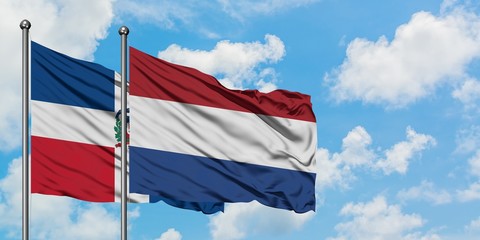 Dominican Republic and Netherlands flag waving in the wind against white cloudy blue sky together. Diplomacy concept, international relations.