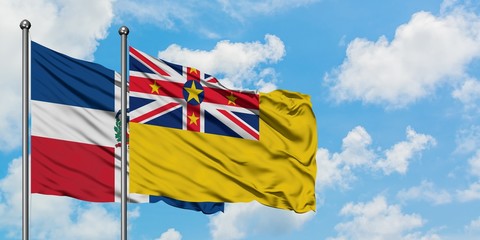 Dominican Republic and Niue flag waving in the wind against white cloudy blue sky together. Diplomacy concept, international relations.