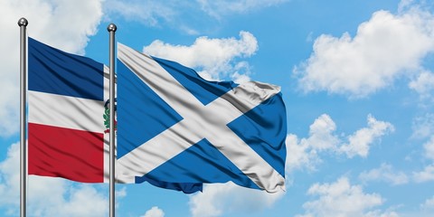 Dominican Republic and Scotland flag waving in the wind against white cloudy blue sky together. Diplomacy concept, international relations.