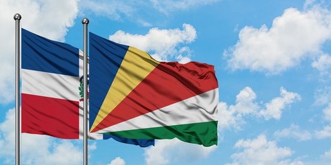 Dominican Republic and Seychelles flag waving in the wind against white cloudy blue sky together. Diplomacy concept, international relations.