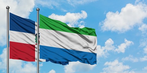 Dominican Republic and Sierra Leone flag waving in the wind against white cloudy blue sky together. Diplomacy concept, international relations.