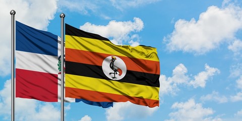 Dominican Republic and Uganda flag waving in the wind against white cloudy blue sky together. Diplomacy concept, international relations.