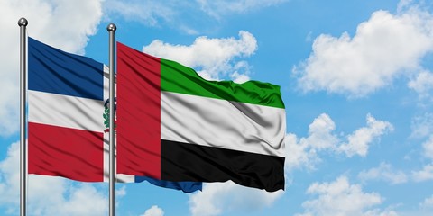 Dominican Republic and United Arab Emirates flag waving in the wind against white cloudy blue sky together. Diplomacy concept, international relations.