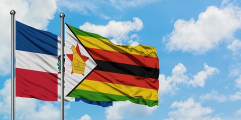 Dominican Republic and Zimbabwe flag waving in the wind against white cloudy blue sky together. Diplomacy concept, international relations.