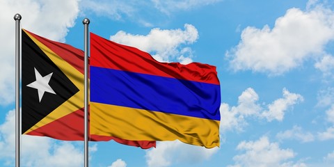 East Timor and Armenia flag waving in the wind against white cloudy blue sky together. Diplomacy concept, international relations.
