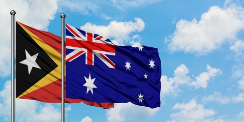 East Timor and Australia flag waving in the wind against white cloudy blue sky together. Diplomacy concept, international relations.