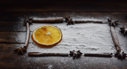 Christmas still life of dried oranges, cinnamon, star anise powdered sugar