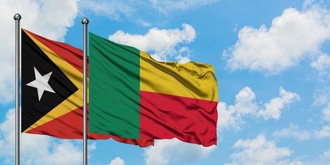 East Timor and Benin flag waving in the wind against white cloudy blue sky together. Diplomacy concept, international relations.