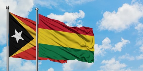 East Timor and Bolivia flag waving in the wind against white cloudy blue sky together. Diplomacy concept, international relations.