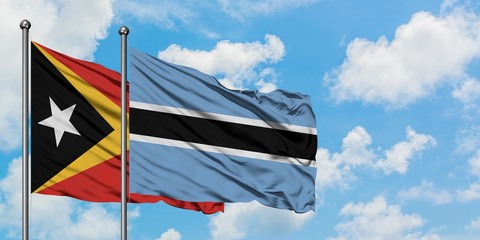 East Timor and Botswana flag waving in the wind against white cloudy blue sky together. Diplomacy concept, international relations.