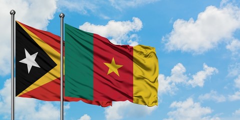 East Timor and Cameroon flag waving in the wind against white cloudy blue sky together. Diplomacy concept, international relations.