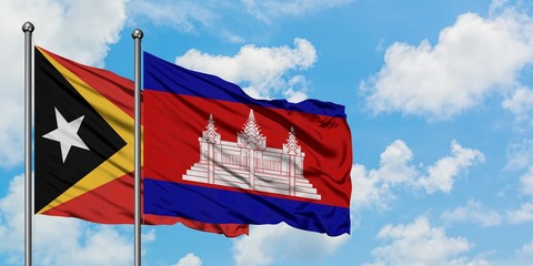 East Timor and Cambodia flag waving in the wind against white cloudy blue sky together. Diplomacy concept, international relations.