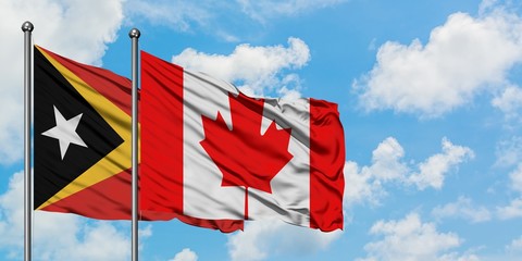 East Timor and Canada flag waving in the wind against white cloudy blue sky together. Diplomacy concept, international relations.