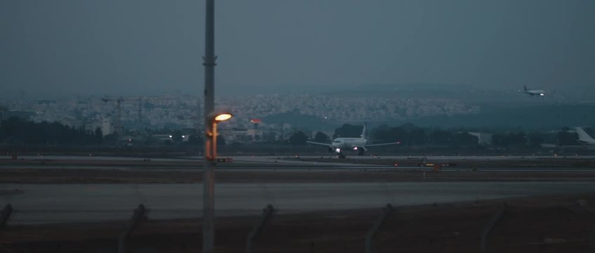 Planes landing and taking off at the runway of an airport, slow motion, handheld. Long shot, BMPCC 4K
