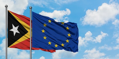 East Timor and European Union flag waving in the wind against white cloudy blue sky together. Diplomacy concept, international relations.