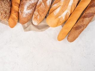Different types of bread on a concrete surface with a cloth.