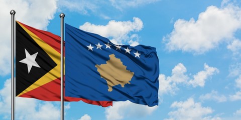 East Timor and Kosovo flag waving in the wind against white cloudy blue sky together. Diplomacy concept, international relations.