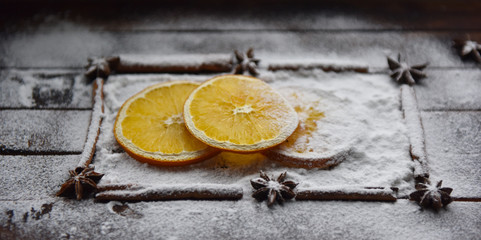Christmas still life of dried oranges, cinnamon, star anise powdered sugar