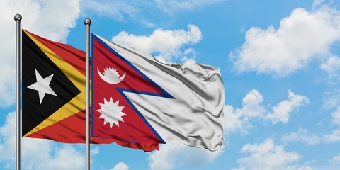 East Timor and Nepal flag waving in the wind against white cloudy blue sky together. Diplomacy concept, international relations.
