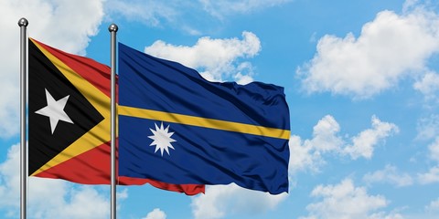 East Timor and Nauru flag waving in the wind against white cloudy blue sky together. Diplomacy concept, international relations.