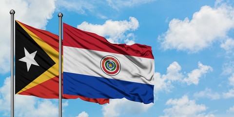East Timor and Paraguay flag waving in the wind against white cloudy blue sky together. Diplomacy concept, international relations.