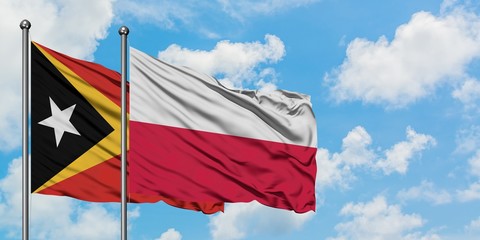 East Timor and Poland flag waving in the wind against white cloudy blue sky together. Diplomacy concept, international relations.