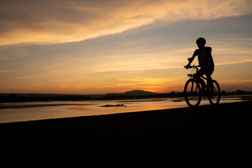 Fototapeta na wymiar Asian men cycling bicycle on the road in the sunset time