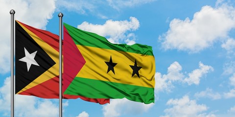 East Timor and Sao Tome And Principe flag waving in the wind against white cloudy blue sky together. Diplomacy concept, international relations.