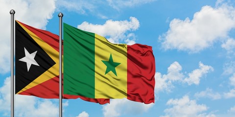 East Timor and Senegal flag waving in the wind against white cloudy blue sky together. Diplomacy concept, international relations.