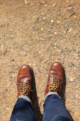 man wearing leather boots standing on country road, close up safty shoes