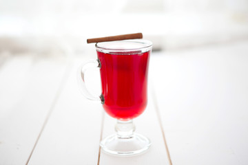 Mulled wine with cinnamon sticks on a white wooden background