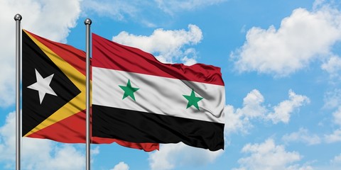 East Timor and Syria flag waving in the wind against white cloudy blue sky together. Diplomacy concept, international relations.