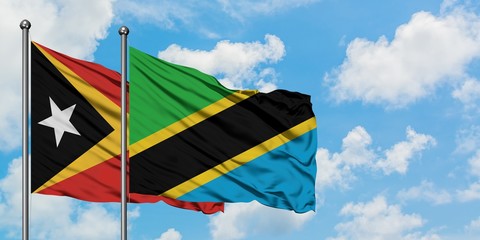 East Timor and Tanzania flag waving in the wind against white cloudy blue sky together. Diplomacy concept, international relations.