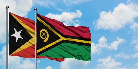 East Timor and Vanuatu flag waving in the wind against white cloudy blue sky together. Diplomacy concept, international relations.